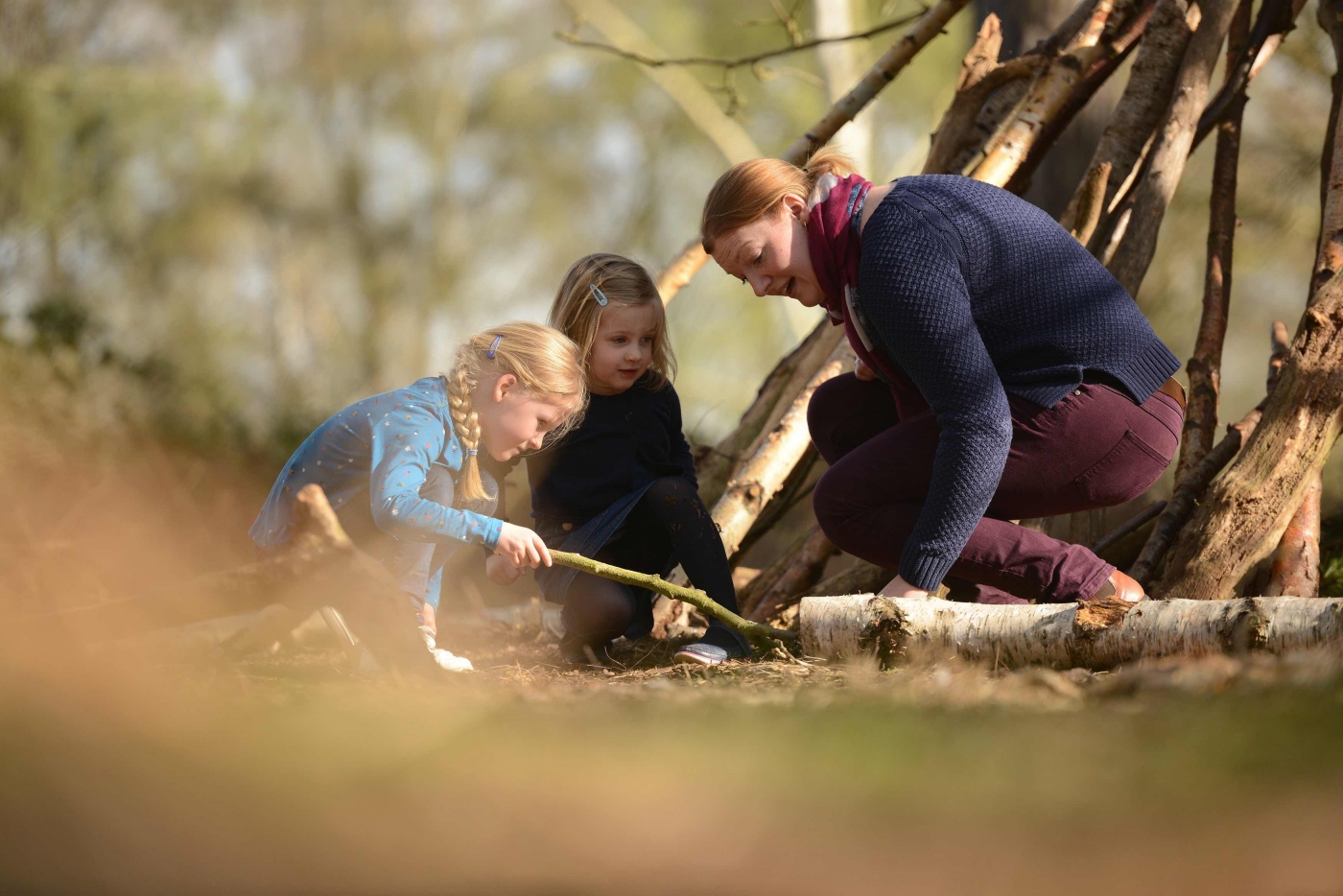 Family investigating under a log
